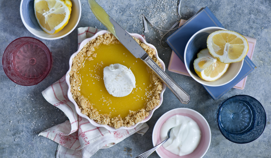 Лимонный пирог на столе с лимонами и сметаной