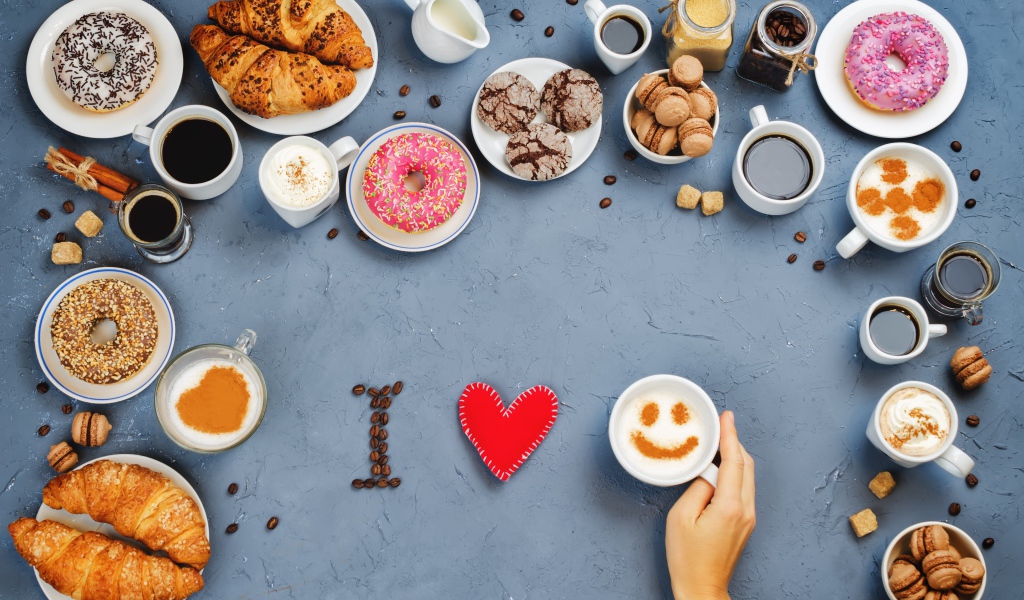 Много сладкой выпечки с кофе на сером фоне