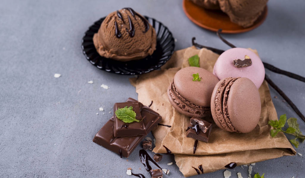 Печенье макарун на серой поверхности с мороженым и шоколадом