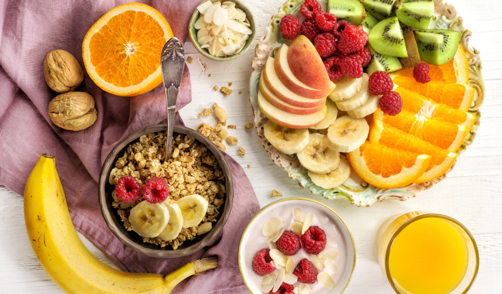 Мюсли на столе фруктами и соком к завтраку