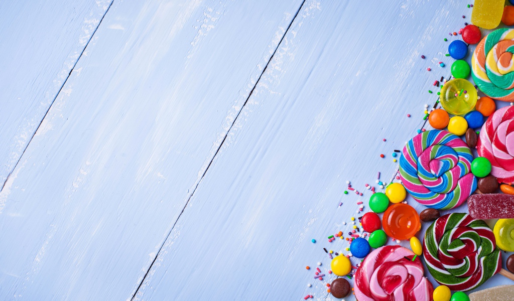 Разноцветные конфеты на голубом столе