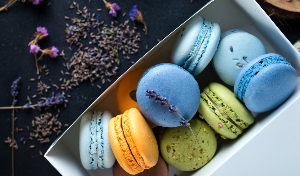 Разноцветный десерт макарон в коробке на столе с лавандой