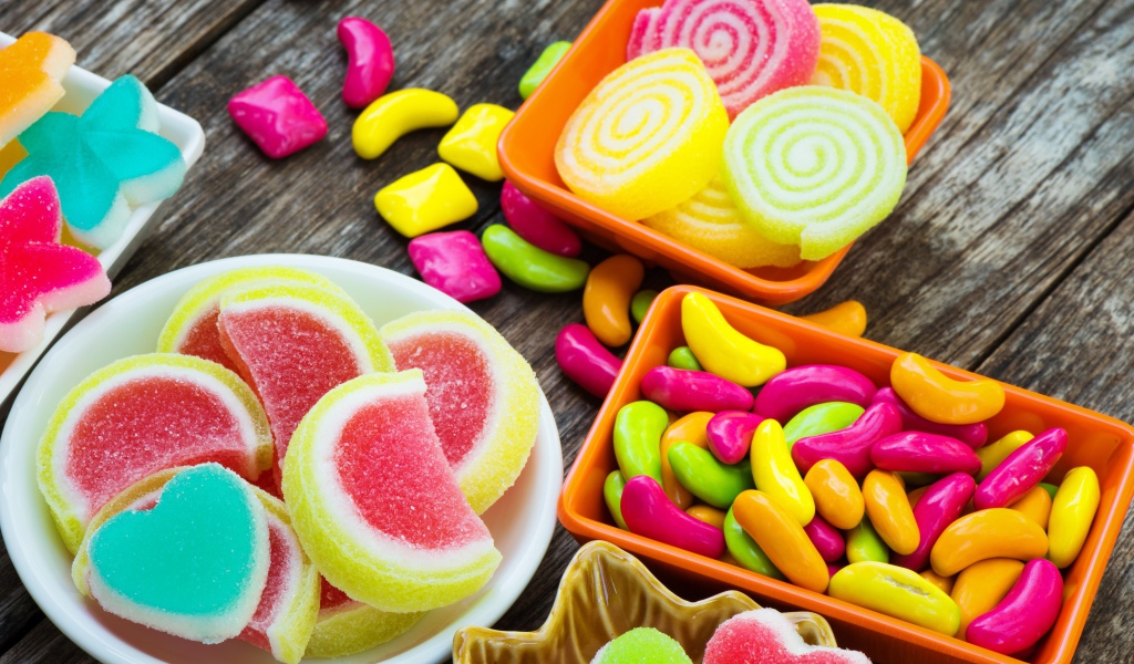 Разноцветный мармелад с конфетами на деревянном столе