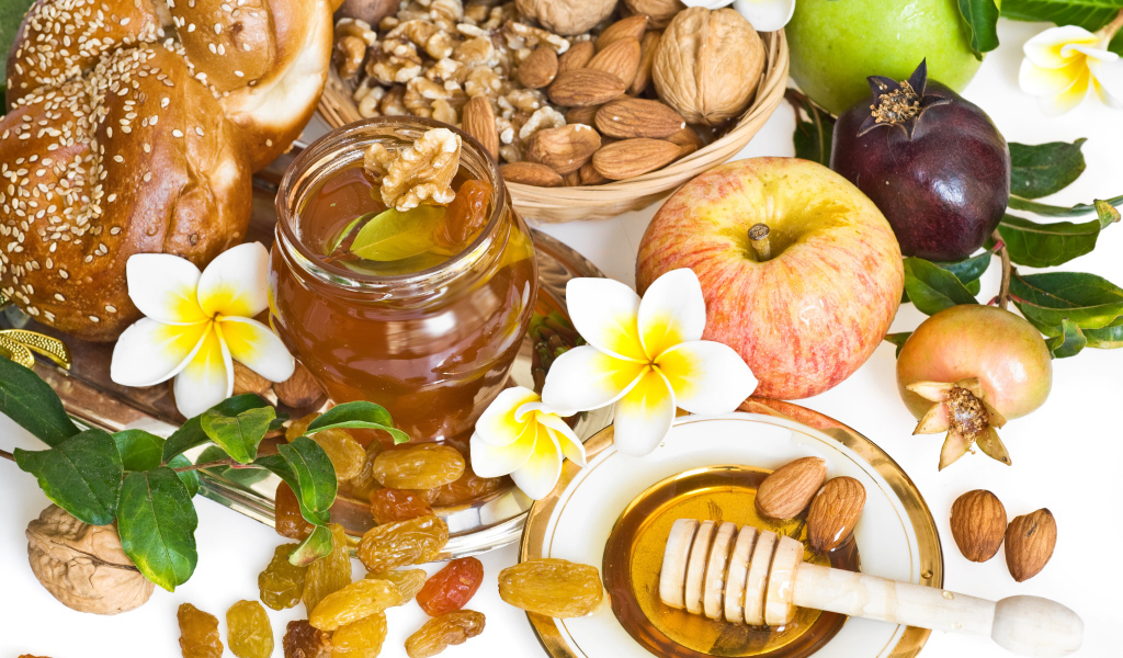 Орехи, мед, яблоки и выпечка с изюмом на столе к празднику