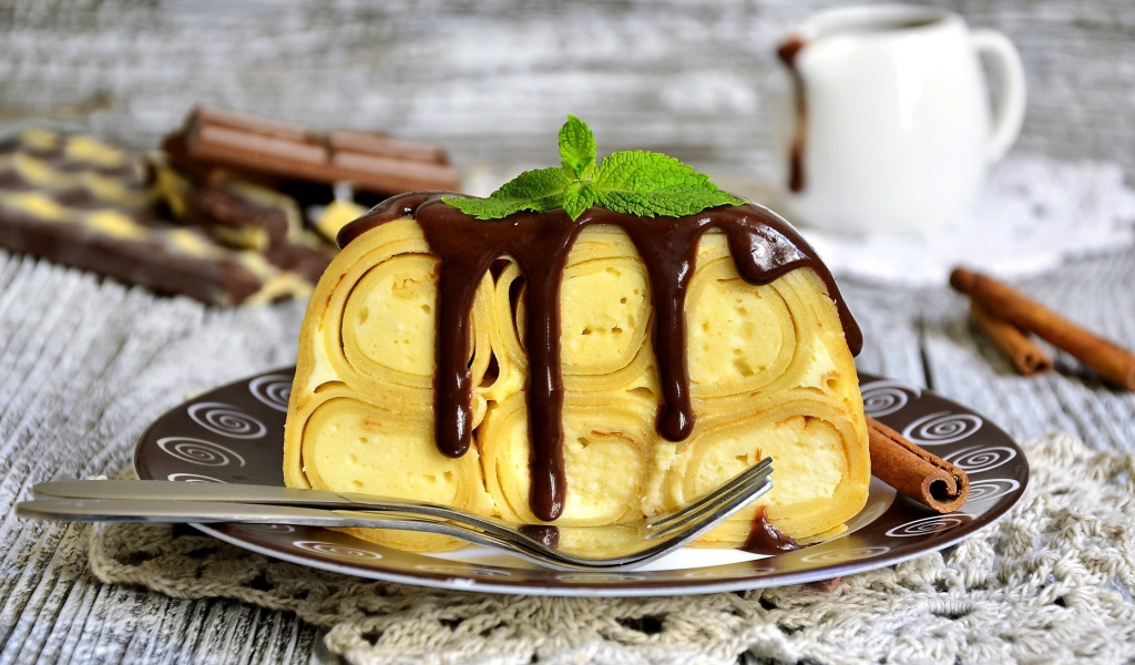 Блинный торт с творогом и шоколадом на тарелке 