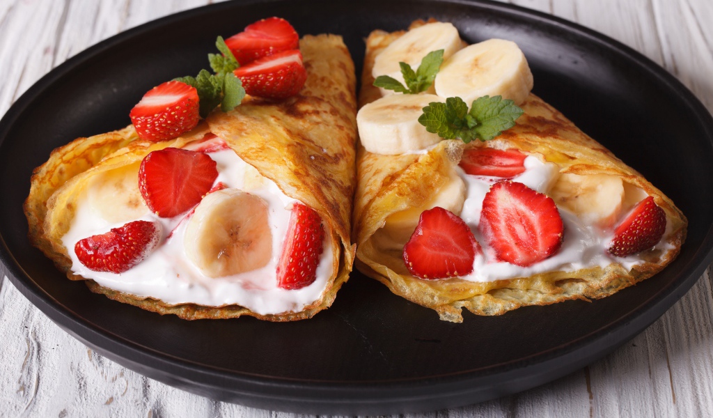 Блинчики со сметаной, бананами и клубникой на сковороде 