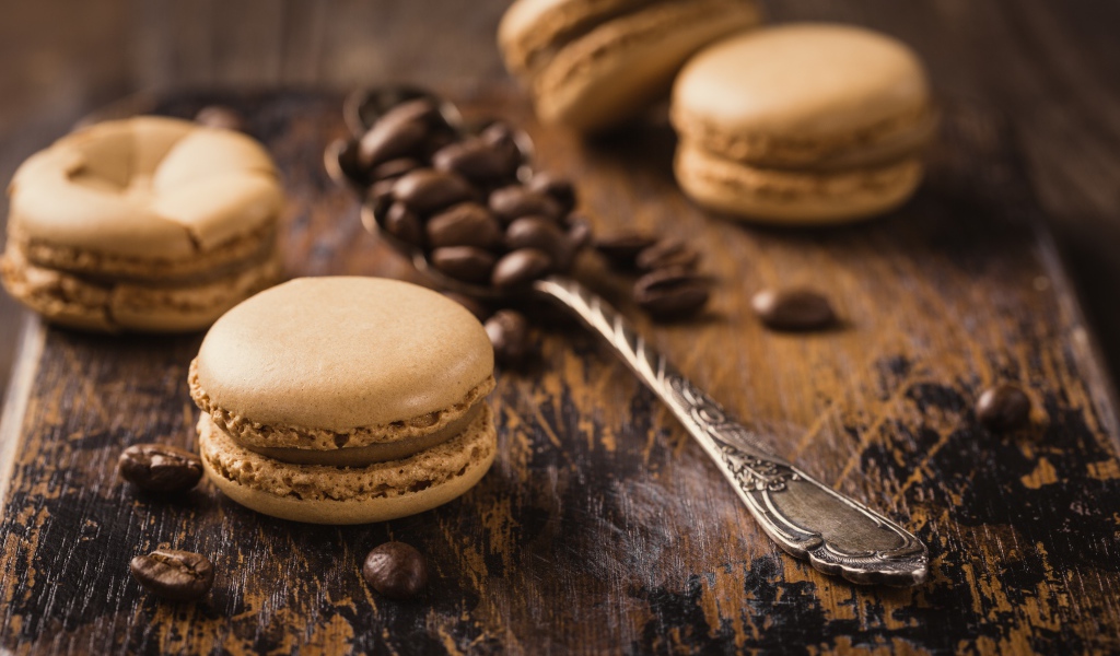 Печенье макарон на столе с ложкой и кофейными зернами