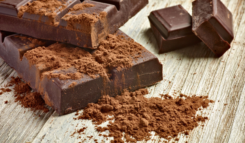 Куски шоколада с какао на деревянном столе 