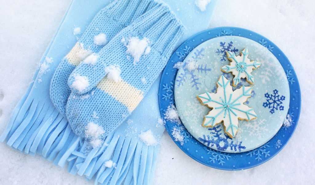 Печенье снежинки на снегу с шарфом и рукавицами