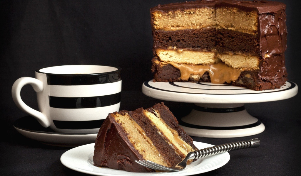 Бисквитный торт на столе с чашкой 