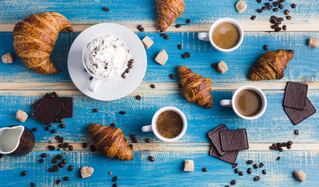 Сладости с кофе на голубом столе