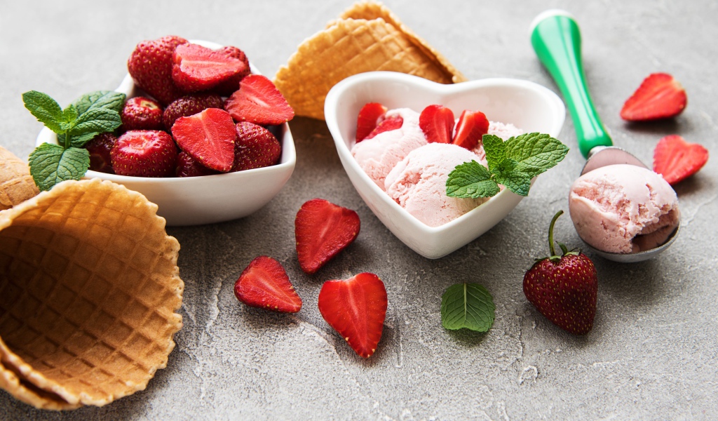 Вкусное мороженое на столе с клубникой и вафельными рожками