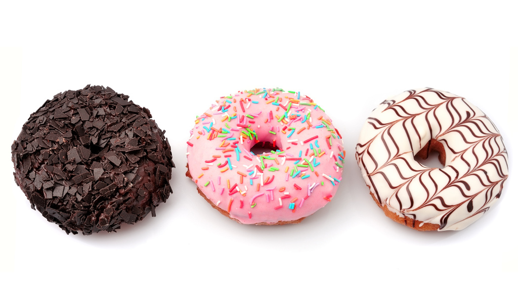 Три аппетитных сладких пончика с глазурью на белом фоне