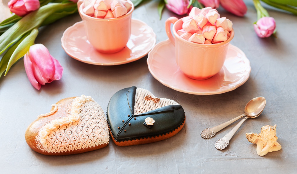 Две розовые чашки с маршмеллоу на сером фоне с печеньем и тюльпанами