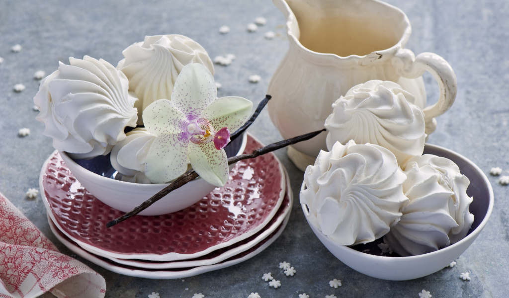 Белый зефир на столе с цветком орхидеи