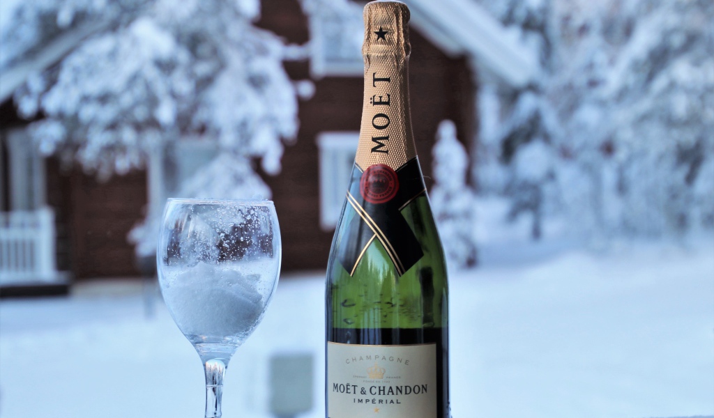 Бокал на снегу с бутылкой шампанского 