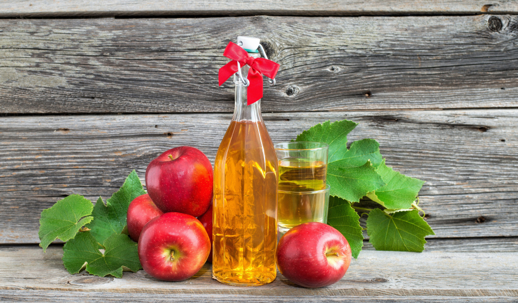 Яблочный сок на столе с красными яблоками