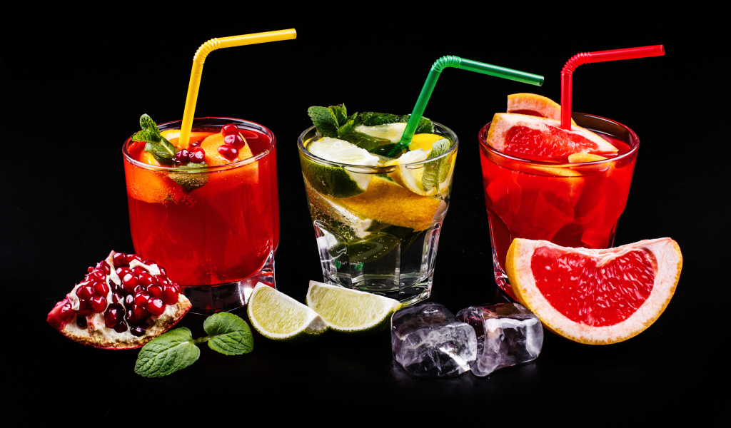 Цитрусовые алкогольные коктейли на черном фоне с фруктами