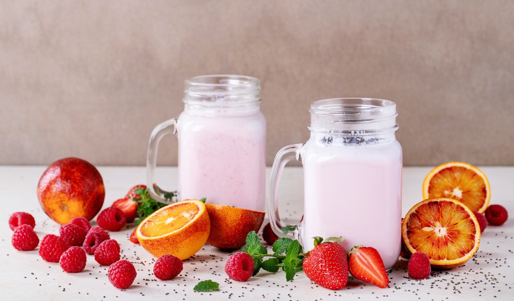 Коктейль на столе с малиной, клубникой и грейпфрутом