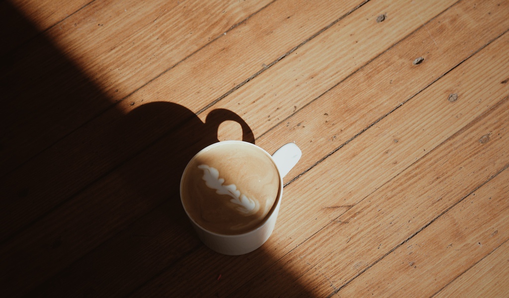 Чашка капучино с рисунком на деревянном столе
