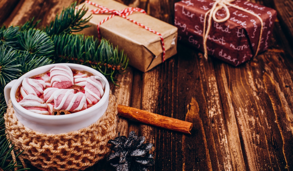 Чашка какао с маршмеллоу на столе с подарками