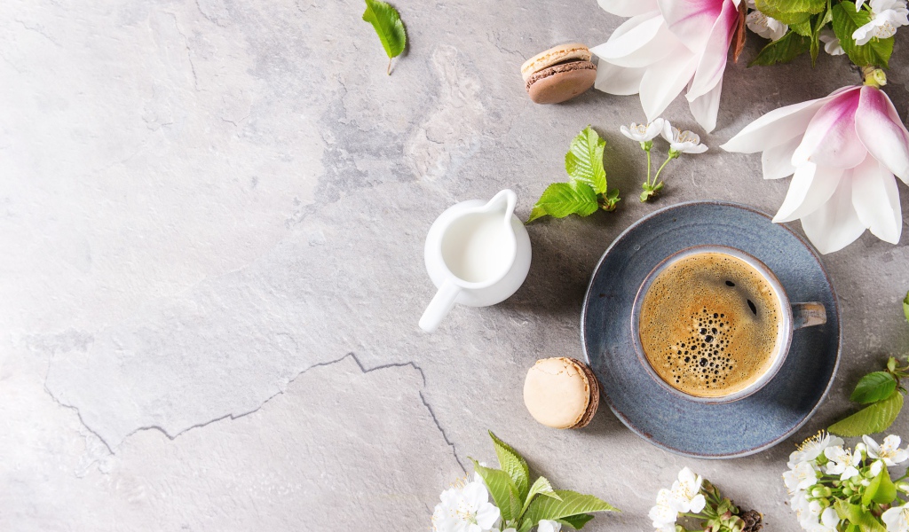 Чашка кофе на сером фоне с цветами вишни и магнолии