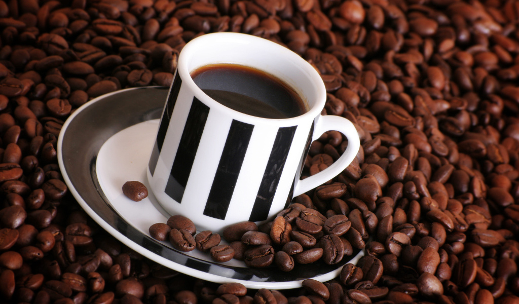 Чашка кофе на столе с кофейными зернами