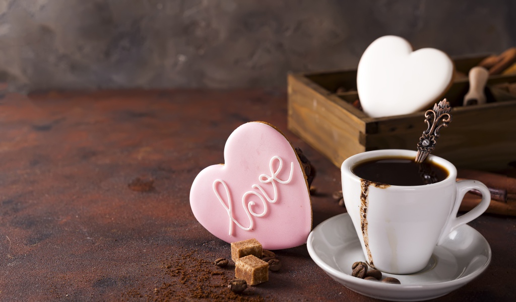 Чашка кофе на столе с сахаром и печеньем в форме сердца 