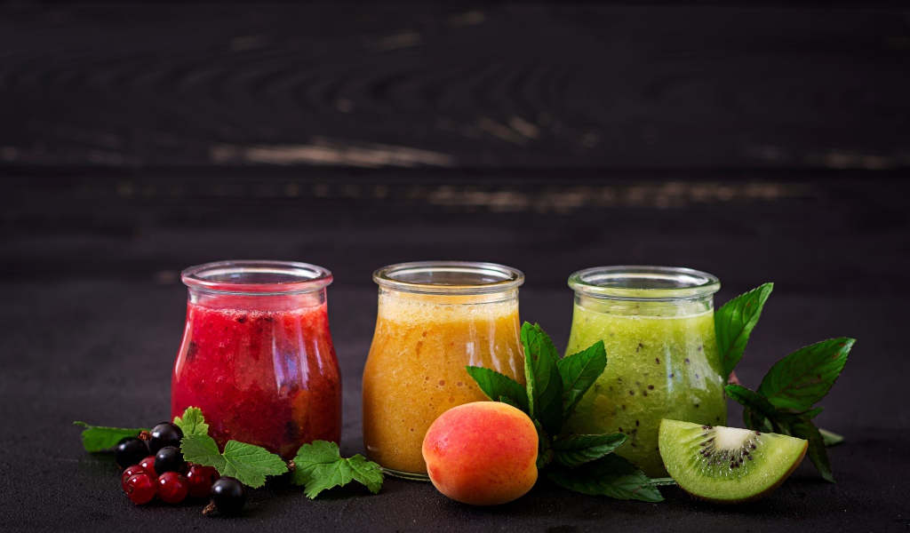 Фруктовое смузи в баночках на столе 
