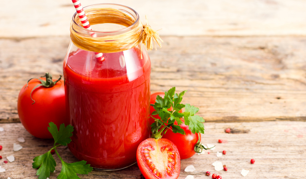 Банка томатного сока на столе с помидорами и петрушкой