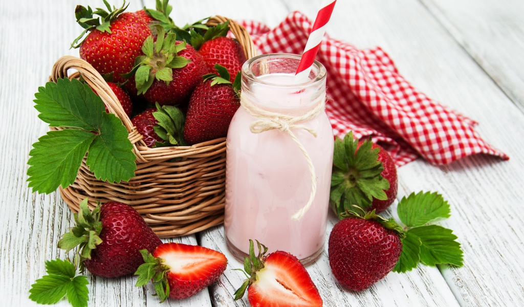 Банка с коктейлем на столе с ягодами клубники