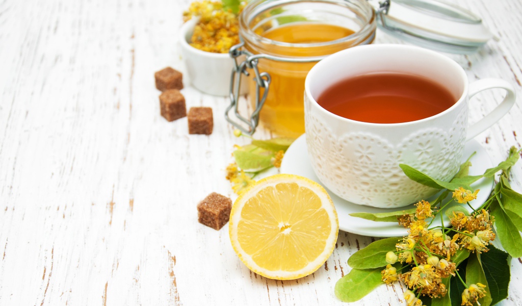 Липовый чай на столе с медом, лимоном, и сахаром