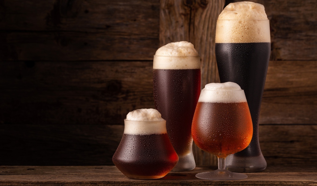 Много бокалов холодного пенного пива на столе 