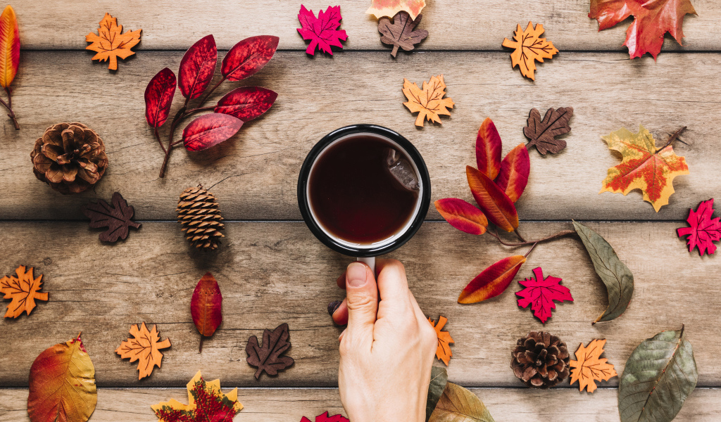 Кружка чая на столе с осенними листьями