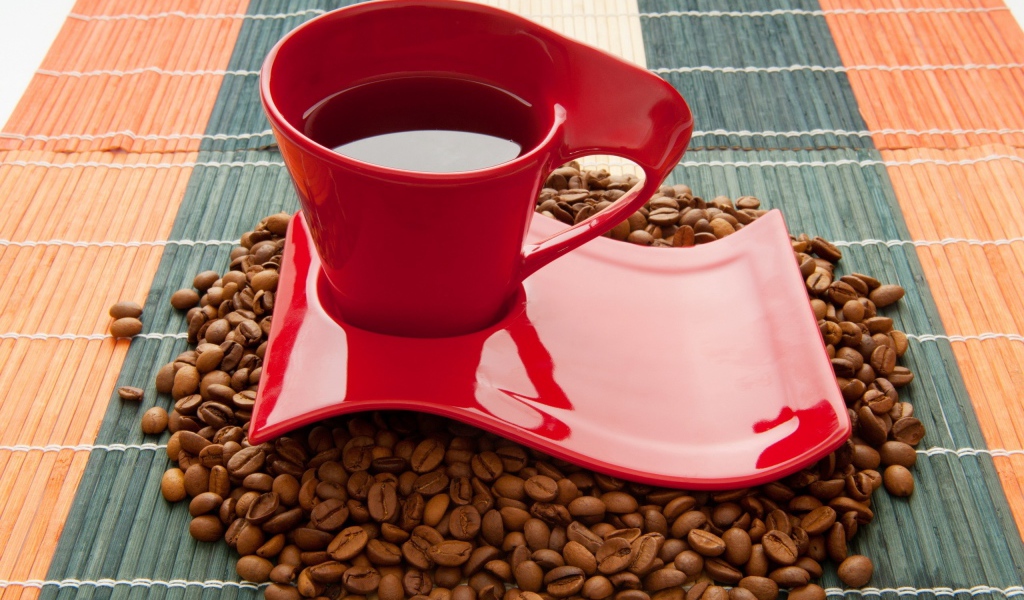 Красная чашка стоит на кофейных зернах 