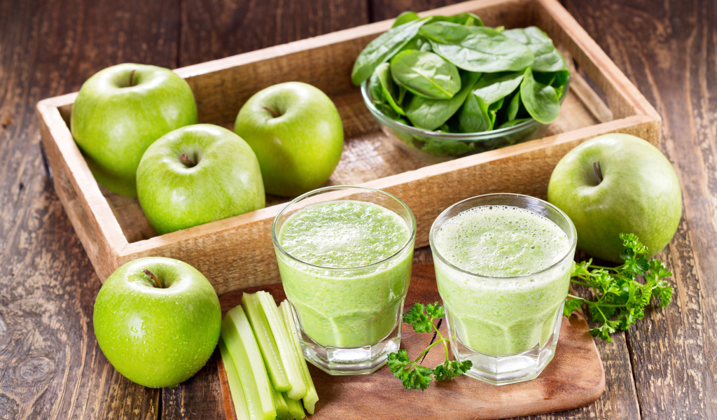 Смузи на столе с зелеными яблоками и зеленью 