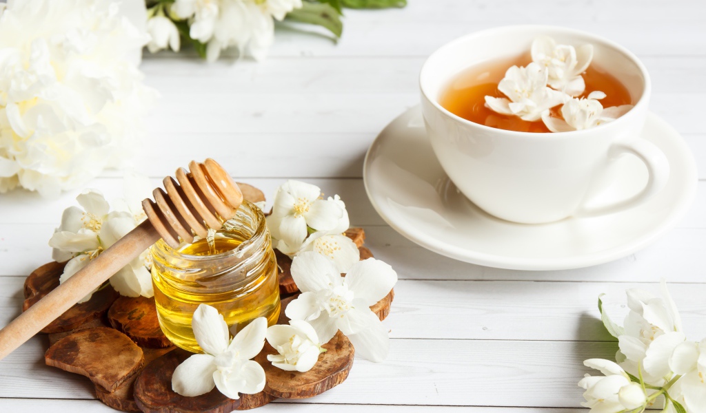 Чай на столе с медом и цветами жасмина