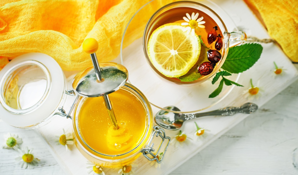 Чай с лимоном и шиповником на столе с медом