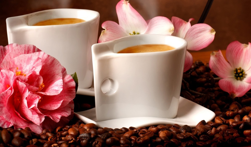 Две чашки кофе на столе с кофейными зернами и цветами