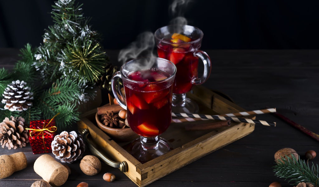 Два стакана горячего глинтвейна на столе с еловой веткой