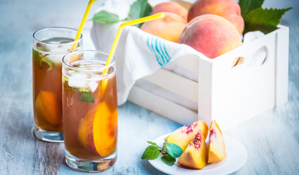 Два стакана сока на столе с персиками