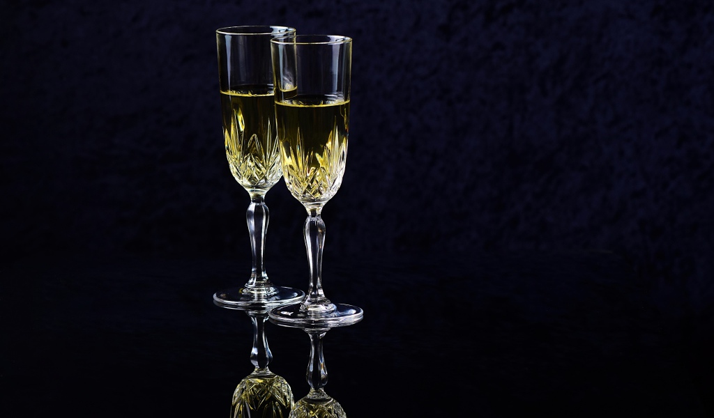 Два бокала с шампанский на черном фоне