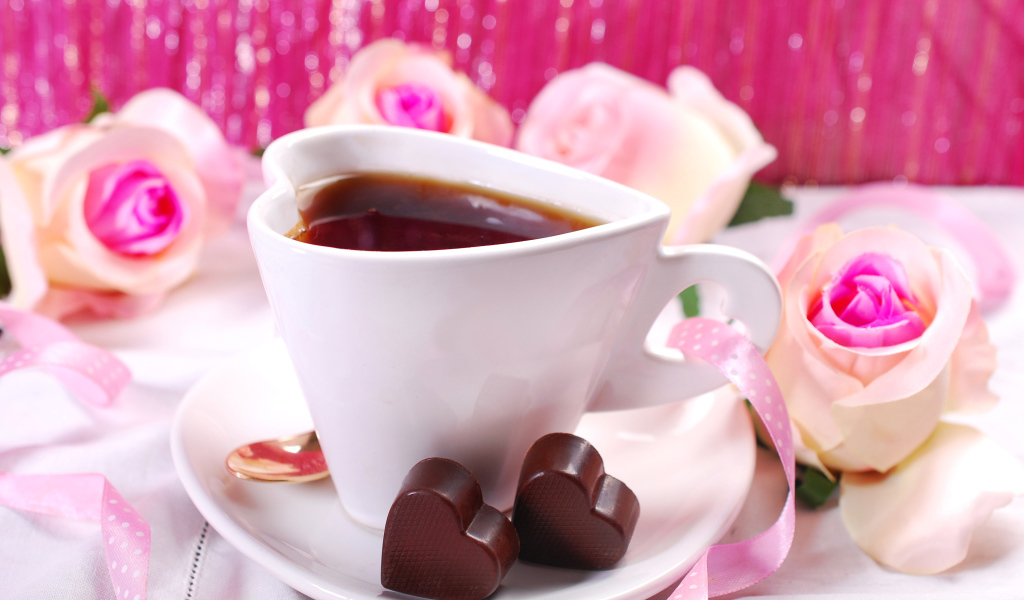 Белая чашка в форме сердца с кофе на блюдце с конфетами