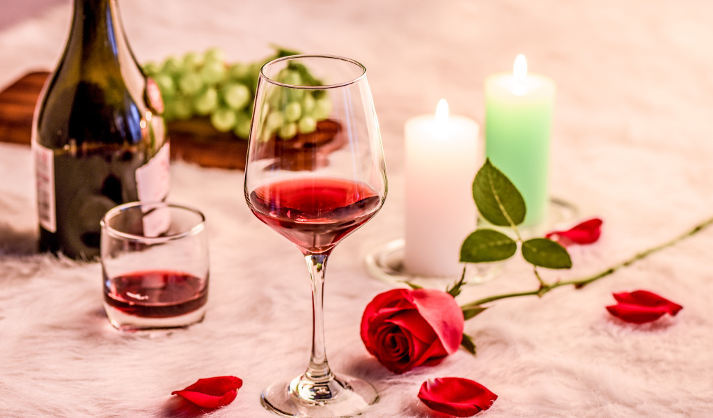 Вино на кровати с розой, виноградом и зажженными свечами