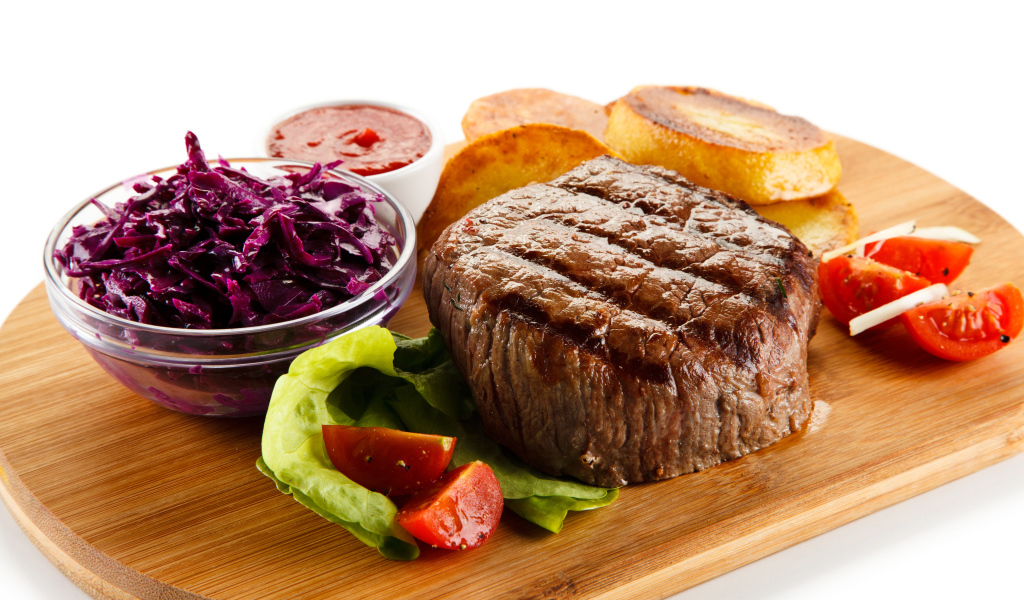 Кусок мяса гриль на доске с салатом и овощами