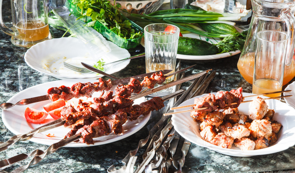 Аппетитный шашлык на шампурах на столе 