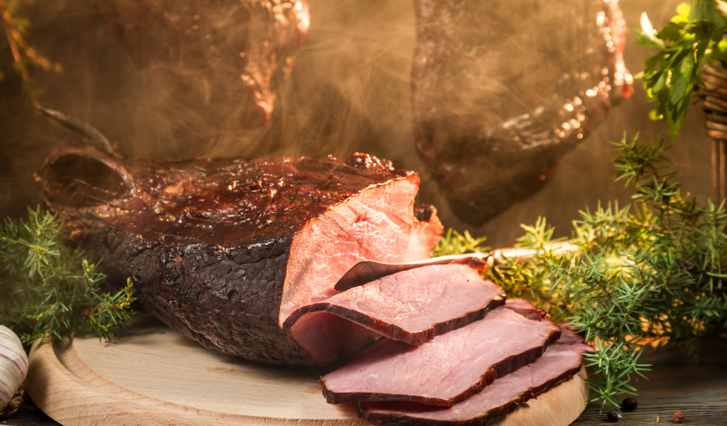 Аппетитный кусок сочной ветчины нарезан на разделочной доске