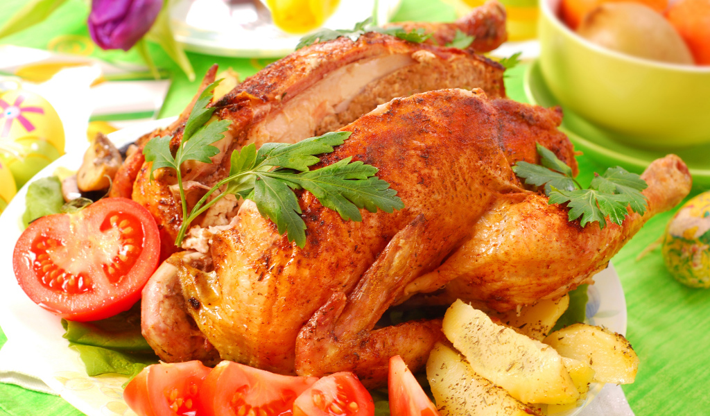 Запеченная курица на столе со свежими помидорами