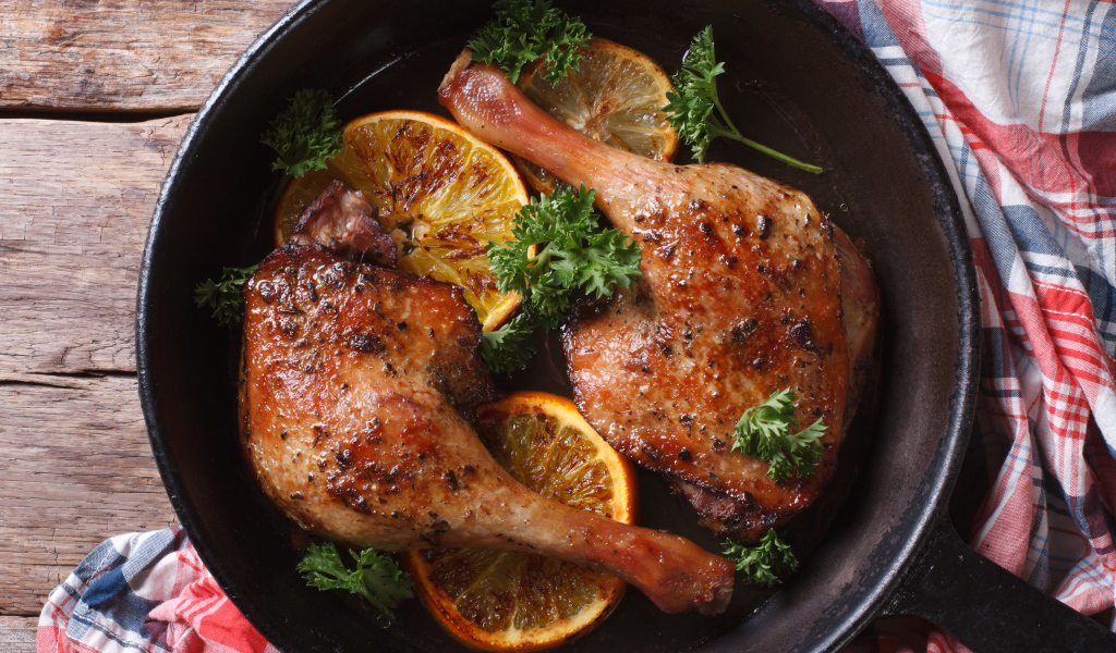 Куриные окорочка в сковороде с кольцами апельсина и петрушкой