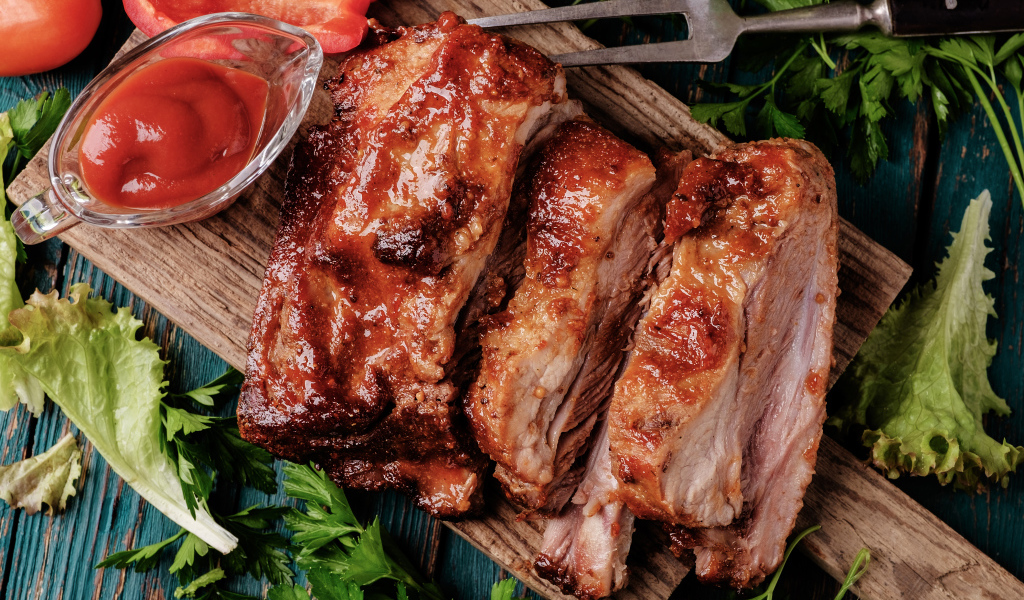 Сочный кусок запеченного мяса на столе с соусом